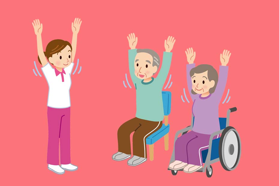 Ein Senior auf einem Stuhl und eine Seniorin im Rollstuhl heben bei der Sitzgymnastik die Hände nach oben. Links daneben steht eine Pflegerin, die auch ihre Arme hoch hebt.